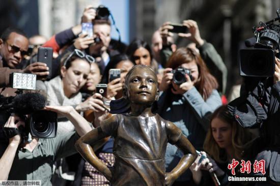 当地时间3月15日，美国纽约华尔街上，一尊名为&ldquo;无所畏惧的女孩&rdquo;铜像成为人们争相合影的新景点。该铜像在3月8日建起，女孩双手叉腰面朝著名的华尔街铜牛。据悉，该作品是一家企业为了唤起女性领导力量，加入到公司的董事层。该雕像由艺术家克里斯汀&middot;比斯瓦尔创作，将在纽约曼哈顿展出至少一周的时间。