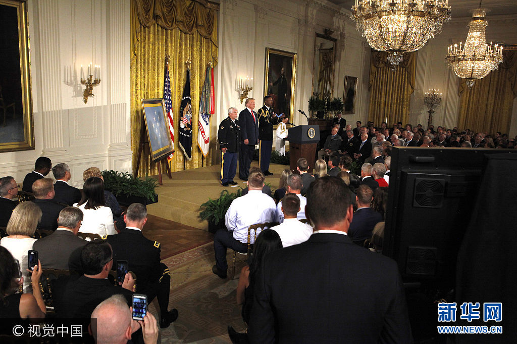 当地时间2017年7月31日，美国华盛顿，美国总统特朗普在白宫为退伍陆军军医James McCloughan授予荣誉勋章，James McCloughan曾在越南战争时期担任军医。***_***President Donald Trump presenting the Medal of Honor to former Specialist Five James C. McCloughan, U.S. Army.in the East Room of the White House on July 31, 2017 Photo by Dennis Brack Photo via Newscom