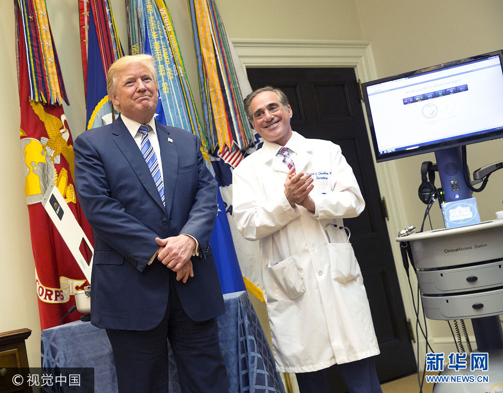 当地时间2017年8月3日，美国华盛顿，美国总统特朗普参观退伍军人事务部，与退伍军人事务部部长大卫·舒尔金共同见证使用视频和软件科技为退伍军人提供医疗帮助的新项目。***_***WASHINGTON, DC - AUGUST 3: (AFP OUT) U.S. President Donald J. Trump(left) listens to applause with Veterans Affairs Secretary Dr.David Shulkin(right) at the announcement  by the Department of Veterans Affairs outlining a new program using video and software technology to provide medical care to veterans at The White House August 3, 2017 in Washington, DC.  (Photo by Chris Kleponis-Pool/Getty Images)