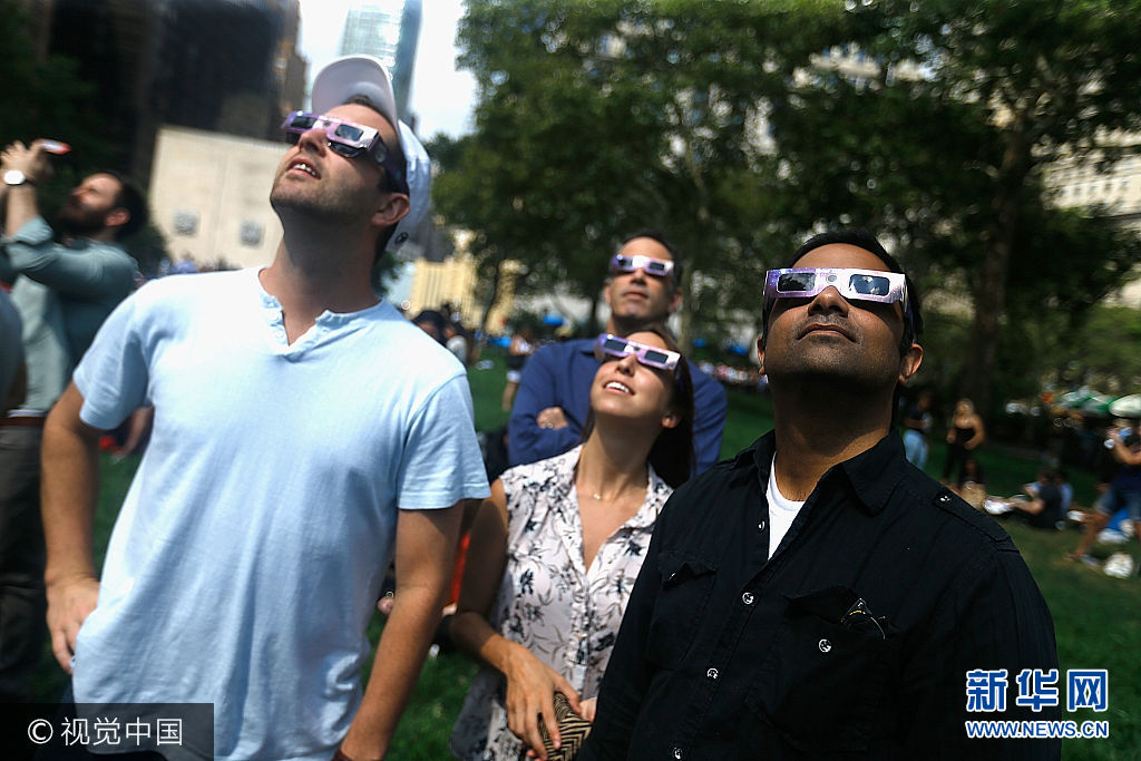 当地时间2017年8月21日，美国纽约，民众在户外观看日全食奇观。***_***NEW YORK, NY - AUGUST 21:  People view the solar eclipse at Battery Park on August 21, 2017 in New York City.  (Photo by John Lamparski/WireImage)