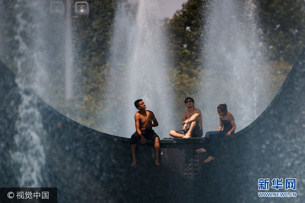 当地时间2017年8月22日，美国纽约，当地遭遇极端炎热天气，气温接近100华氏度（约37摄氏度），民众在公园喷泉旁降温。***_***NEW YORK, NY - AUGUST 22: Teens cool off in the fountains at the Unisphere steel structure at Flushing Meadows-Corona Park, August 22, 2017 in the Queens borough of New York City. With heat index values near 100, the New York City area is under a heat advisory on Tuesday. (Photo by Drew Angerer/Getty Images)
