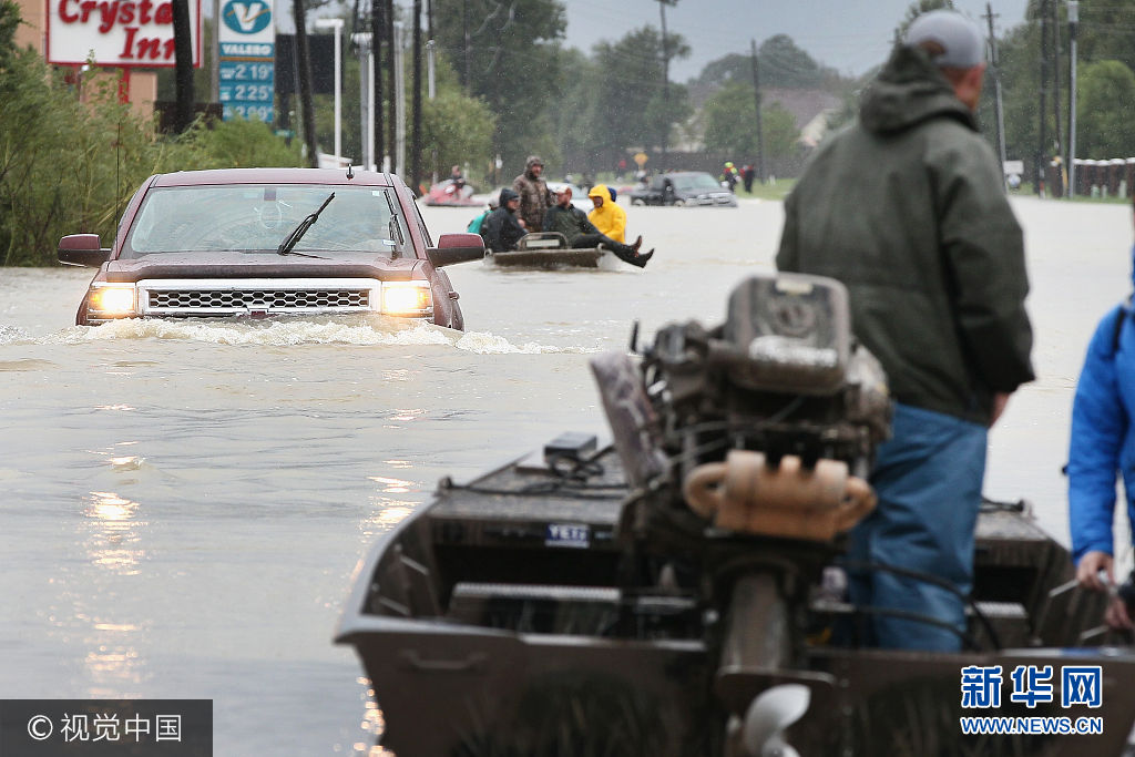当地时间2017年8月29日，美国得克萨斯州，飓风“哈维”重创得州，灾民疏散工作持续。***_***HOUSTON, TX - AUGUST 29:  Rescue workers and volunteers help residents make their way out of a flooded neighborhood after it was inundated with rain water following Hurricane Harvey on August 29, 2017 in Houston, Texas. Harvey, which made landfall north of Corpus Christi August 25, has dumped nearly 50 inches of rain in and around areas Houston.  (Photo by Scott Olson/Getty Images)