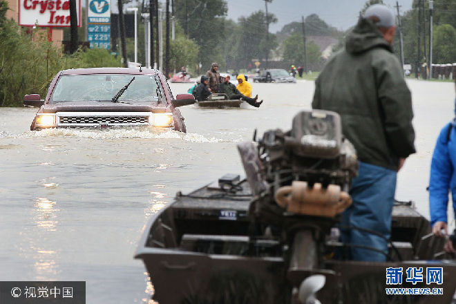 當地時間2017年8月29日，美國得克薩斯州，颶風“哈維”重創得州，災民疏散工作持續。***_***HOUSTON, TX - AUGUST 29:  Rescue workers and volunteers help residents make their way out of a flooded neighborhood after it was inundated with rain water following Hurricane Harvey on August 29, 2017 in Houston, Texas. Harvey, which made landfall north of Corpus Christi August 25, has dumped nearly 50 inches of rain in and around areas Houston.  (Photo by Scott Olson/Getty Images)