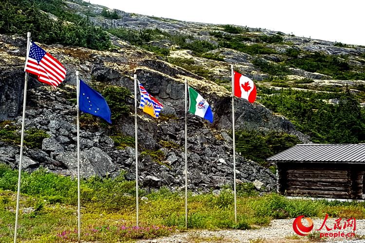在美加邊界線附近飄揚著5面旗幟：美國國旗、阿拉斯加州旗、加拿大BC省旗、育空區旗和加拿大國旗  于世文  攝 