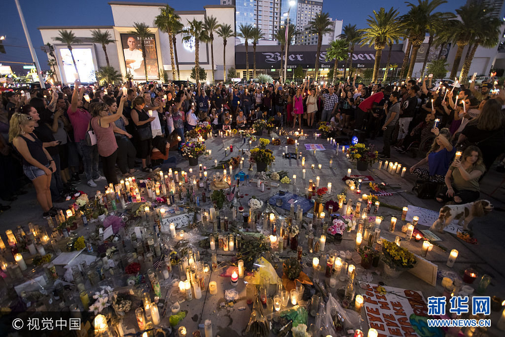 当地时间2017年10月8日，美国拉斯维加斯，民众参加烛光守夜，纪念拉斯维加斯枪击案发生一周。***_***LAS VEGAS, NV - OCTOBER 8: Mourners hold their candles in the air during a moment of silence during a vigil to mark one week since the mass shooting at the Route 91 Harvest country music festival, on the corner of Sahara Avenue and Las Vegas Boulevard at the north end of the Las Vegas Strip, on October 8, 2017 in Las Vegas, Nevada. On October 1, Stephen Paddock killed 58 people and injured more than 450 after he opened fire on a large crowd at the Route 91 Harvest country music festival. The massacre is one of the deadliest mass shooting events in U.S. history. (Photo by Drew Angerer/Getty Images)
