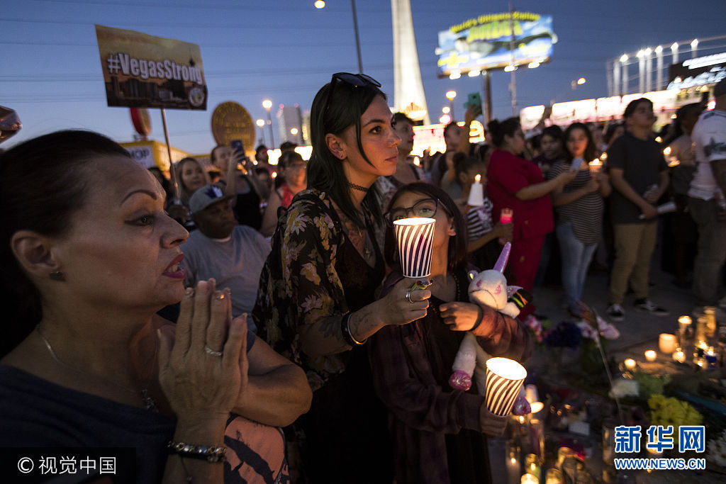 当地时间2017年10月8日，美国拉斯维加斯，民众参加烛光守夜，纪念拉斯维加斯枪击案发生一周。***_***LAS VEGAS, NV - OCTOBER 8: Mourners attend a vigil to mark one week since the mass shooting at the Route 91 Harvest country music festival, on the corner of Sahara Avenue and Las Vegas Boulevard at the north end of the Las Vegas Strip, on October 8, 2017 in Las Vegas, Nevada. On October 1, Stephen Paddock killed 58 people and injured more than 450 after he opened fire on a large crowd at the Route 91 Harvest country music festival. The massacre is one of the deadliest mass shooting events in U.S. history. (Photo by Drew Angerer/Getty Images)