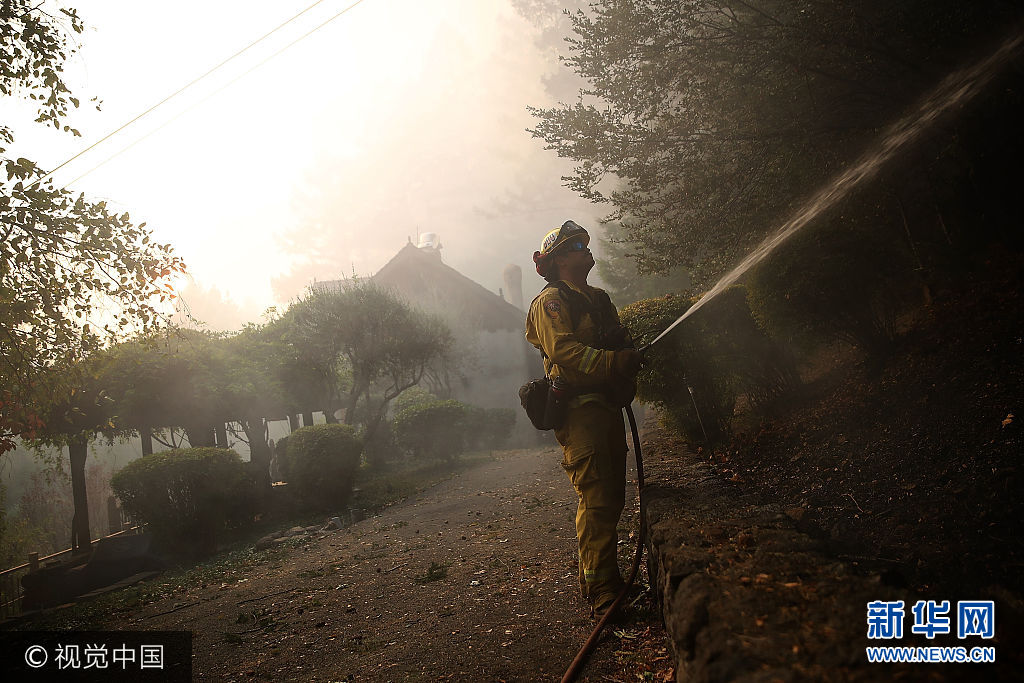當地時間2017年10月12日，美國加州卡利斯托加，從8日晚間開始延燒的美國加州北部山火的過火面積約770平方公里，導致至少29人喪生，數百人失蹤，3500多座建築被毀。***_***CALISTOGA, CA - OCTOBER 12:  A CalFire firefighter uses a hose to monitor hot spots during a firing operation while battling the Tubbs Fire on October 12, 2017 near Calistoga, California. At least thirty one people have died in wildfires that have burned tens of thousands of acres and destroyed over 3,500 homes and businesses in several Northern California counties.  (Photo by Justin Sullivan/Getty Images)
