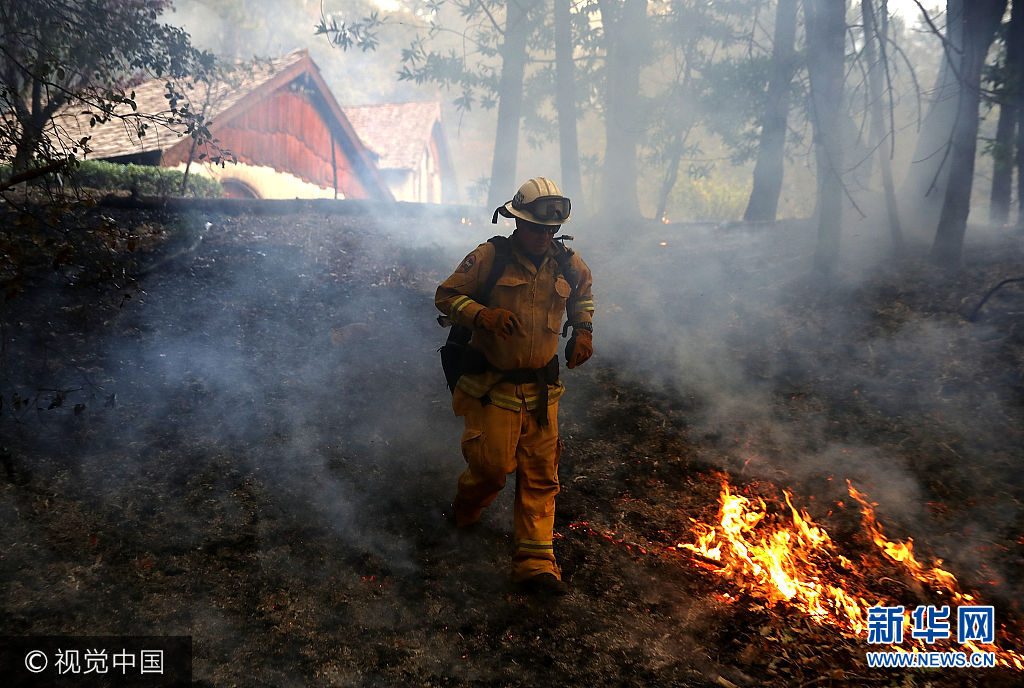当地时间2017年10月12日，美国加州卡利斯托加，从8日晚间开始延烧的美国加州北部山火的过火面积约770平方公里，导致至少29人丧生，数百人失踪，3500多座建筑被毁。***_***CALISTOGA, CA - OCTOBER 12:  A CalFire chief runs past burning grass during a firing operation while battling the Tubbs Fire on October 12, 2017 near Calistoga, California. At least thirty one people have died in wildfires that have burned tens of thousands of acres and destroyed over 3,500 homes and businesses in several Northern California counties.  (Photo by Justin Sullivan/Getty Images)